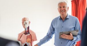 Como avaliar o impacto da entrada e saída de docentes em um Programa de Pós-Graduação? - Um professor de doutorado conduzindo uma palestra de anatomia.